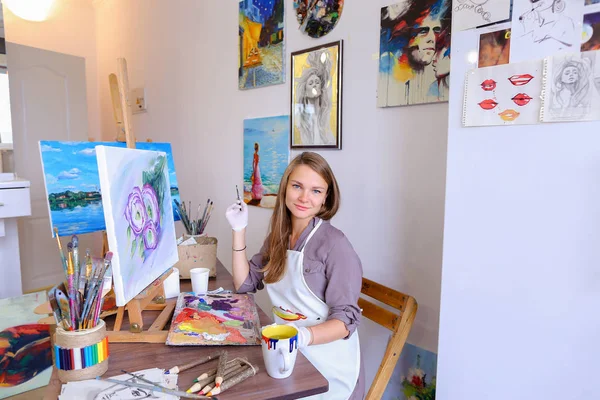 Girl Sits on Stool at Easel And Writing Painting, Uses Brush to — Stok Foto