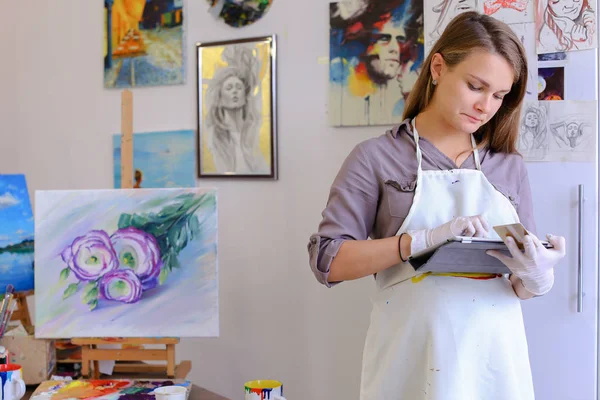 Cute Girl tient et utilise la tablette. Artiste de l'apparition européenne dans — Photo