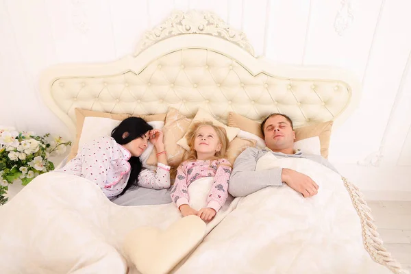 Jong gezin met dochter leugen in witte kamer op bed, meisje wakker u — Stockfoto