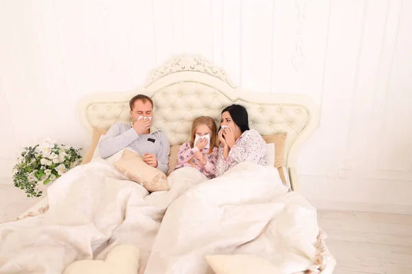 Familia se enfermó, estornudó y se acostó en la cama en casa —  Fotos de Stock