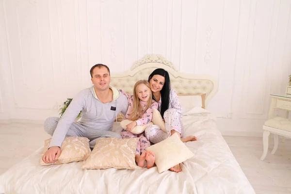 Porträt einer glücklichen Familie im Schlafanzug, die lächelt und den Kameramann anschaut — Stockfoto