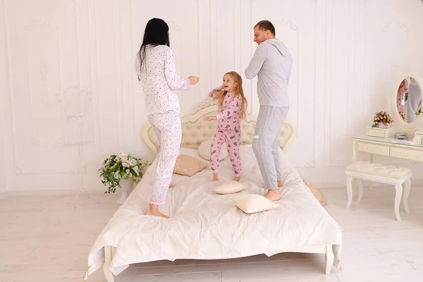 Rodzinne skoki i wygłupiać się w łóżku, mąż i żona walka — Zdjęcie stockowe