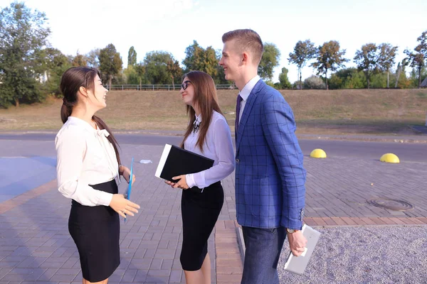Three young successful businessman, students communicate, smilin