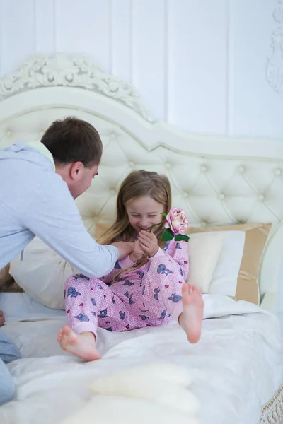 Pai faz cócegas filha, jogado com menina na cama em casa — Fotografia de Stock
