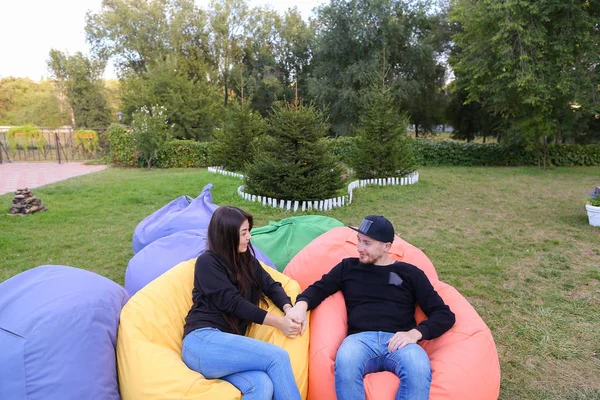 Casal apaixonado sentar e falar em poltronas, sorrindo, abraçando e k — Fotografia de Stock