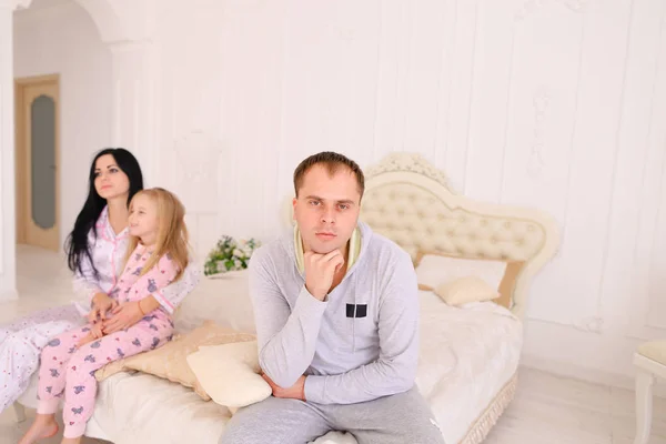 Couple quarrel and child upset, sitting bed in white interior — Stock Photo, Image