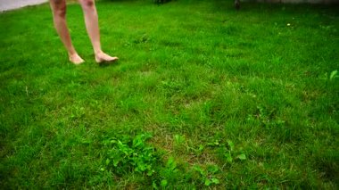 Kız yalınayak güzel bacaklar Park gündüzleri Taze çimenlerin üzerinde yürüyüş.