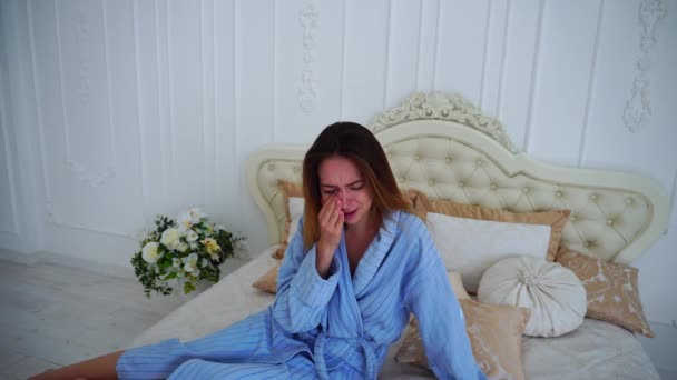 Women in Bad Mood, Upset and Crying, Sitting on Bed in Spacious Bedrooms. — Stock Video