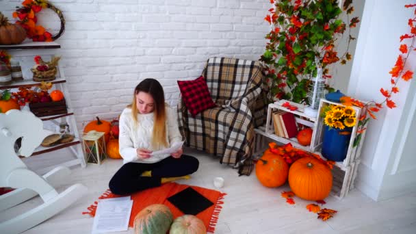 Étudiante faisant des devoirs sur ordinateur et lisant des informations sur les documents allongés sur grand lit dans la chambre . — Video