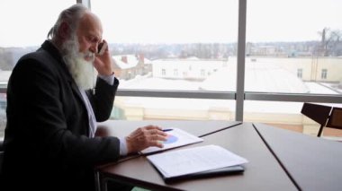 Emekli yaşlı adama telefon ile mali konularda anlaşma için yeni teknoloji kullanarak arama yapar