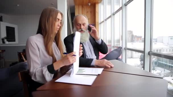 Dvě společnosti kolegy mladá dívka a starý muž mluvit o chytrého telefonu mluvit o problémech v moderní kanceláři v zimě
