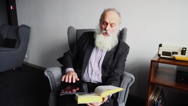Age-Old Man Procurando informações adicionais sobre o trabalho literário com Gadget e Internet, sentado na cadeira no café . — Vídeo de Stock