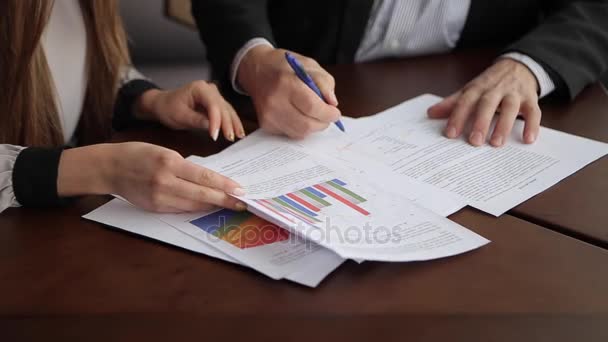 年老的老板和年轻女秘书签署商业文件和签署协议，坐在办公室桌上在白天. — 图库视频影像
