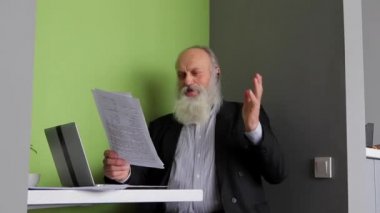 Bankacı yaşlı adam patron mektup onaylama okur ve Bluetooth kulaklık patronun yön gündüz bilgisayar Cafe masada oturan dinler.