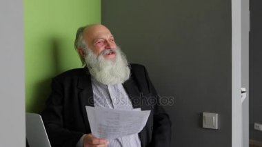 Yaşlı adam neşeli ruh hali gündüzleri ofiste masada oturan kamera arkasında meslektaşları ile çalışan konularda iletişim kurmak için kullandığı.
