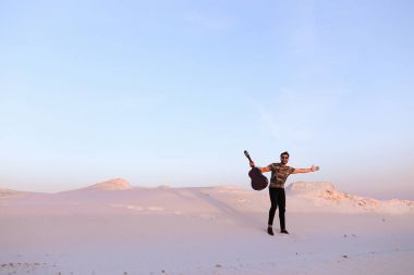 Arap adam çöl güzelliği ile ilham gider ve gitar çi çalış