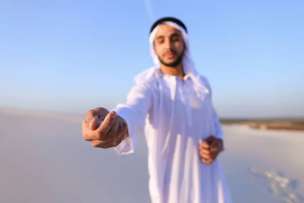 Close-up shot of portrait and hands of young Arab guy in sandy d — Stock Photo, Image