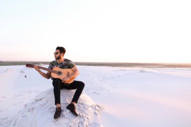 Sevimli genç erkek Arap ses gitar, Hill'de oturan sahiptir