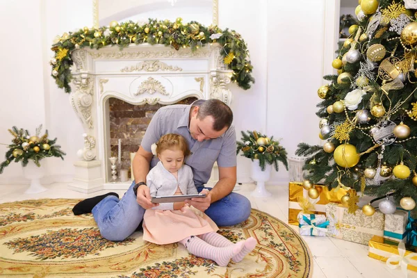 Lindo papá hija y papá jugando en la tableta sentado en el piso i — Foto de Stock