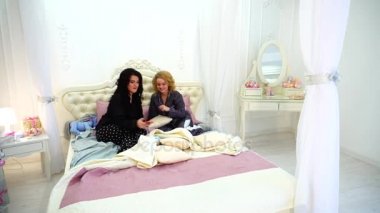 Araç eğlence için kullanabilirsiniz ve sosyalleşme, gece geç saatte yatakta parlak yatak odasında oturma sevimli kız.