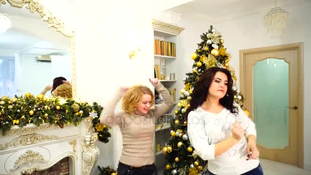 Близкие братья и сестры Элегант отдыхают в зимние каникулы в светлой гостиной с праздничным камином, украшенным праздничным огнем и высокой зимней елкой . — стоковое видео
