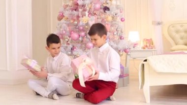 Mutlu çocuklar, hediyeler, Noel ağacı ile rahat yatak odasında oturup düşünen iki kardeş Close-Up çekim.