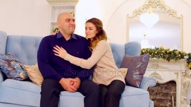 Örnek Aile, sevgi dolu anne ve Noel ağacı ile şenlikli bir şekilde dekore edilmiş oda içinde mavi kanepe ve öğleden sonra şömine oturup oğlu portresi.