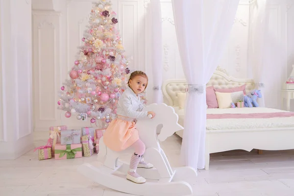 Kleines Mädchen Kind spielt im Kinderzimmer auf rosa Hintergrund — Stockfoto