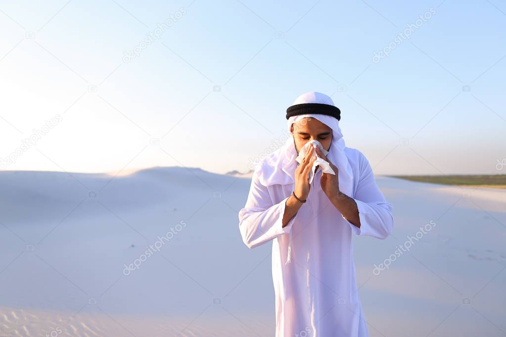 Arabian guy feels unpleasant sensations with cold, standing in m