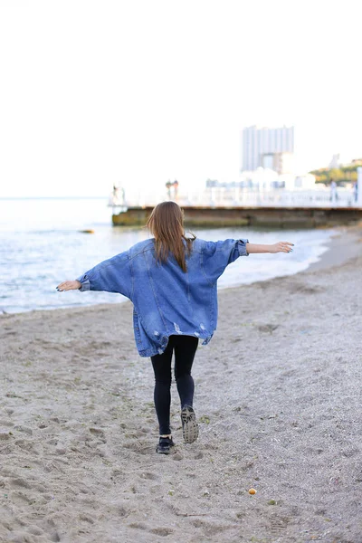 Mulher encantadora com poses de sorriso e caminha ao longo da costa do mar na guerra — Fotografia de Stock