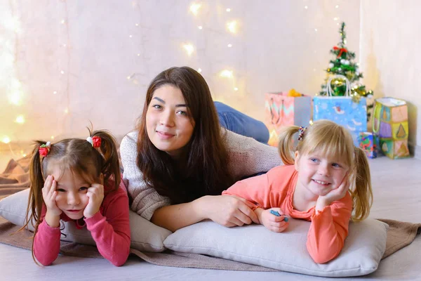 Cute female and two little girls children, posing for camera and