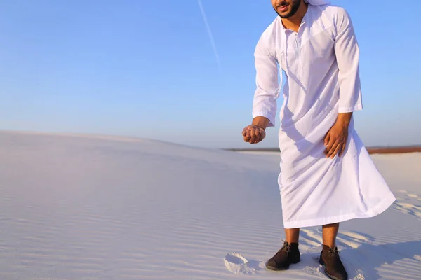 L'homme musulman développe le sable le long du vent, debout au milieu de deser — Photo