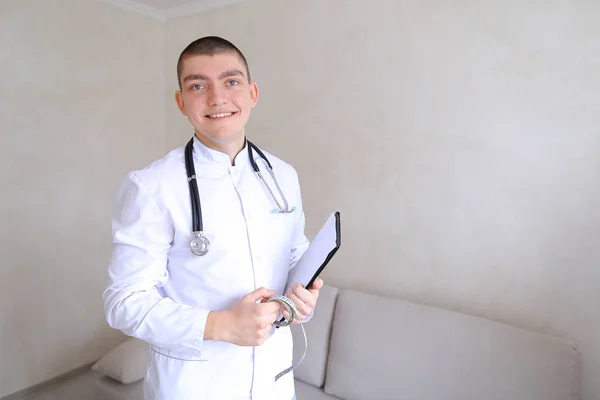 Professionale terapeuta maschile guarda la fotocamera con sorriso e stand — Foto Stock