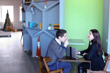 Adam ve kız öğrenciler okuldan sonra kütüphanesinde rahatlayın ve t oturmak