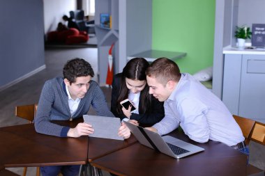 Üç meslektaşları, kadın ve iki genç adamın sosyal ağ içinde oturmak