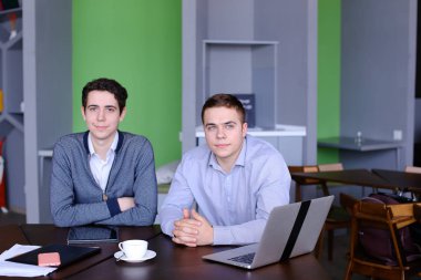 İki yakışıklı zeki işadamı veya tablo zekâ oturan çalışanlar