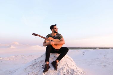 Çekici Arap adam gitar, Hill'de oturan şarkı söylüyor