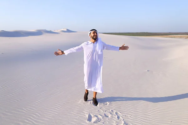 Happy Arab man walks in middle of white desert and enjoys life o — Stock Photo, Image