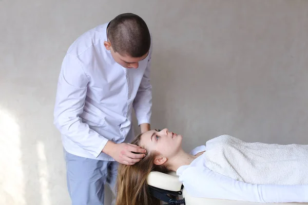 Bonito cara massagem terapeuta fazendo massagem na cabeça para clien menina — Fotografia de Stock