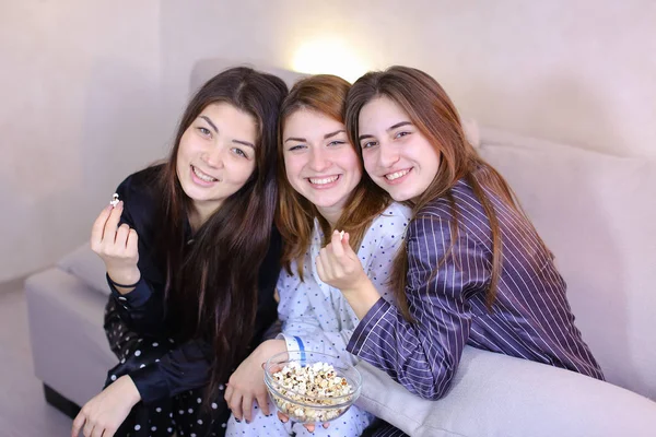 Vriendelijke vriendinnen cool tijd doorbrengen en eten popcorn, zittend — Stockfoto
