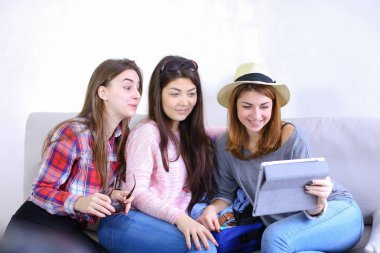 Yakın arkadaşlar tablet kullanmak ve iyi eğlenceler, ro koltukta oturmak