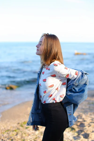 Charmante fille se promène le long de la côte et joyeux idiots autour sur le sable — Photo