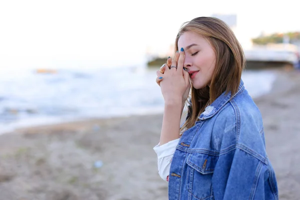 Mooie vrouw glimlacht eenvoudig en kijkt naar de horizon, staande op sho — Stockfoto