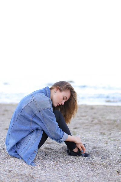 Beautiful girl resting, sitting by sea and posing on camera on b — Stock Photo, Image