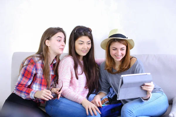 Close female friends use tablet and have fun, sit on couch in ro — Stock Photo, Image