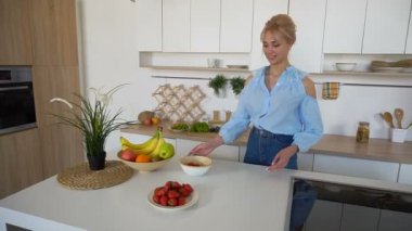 Modern parlak mutfak masasında duran sabah sabah kahvaltı için poz şık kız aşçılar.