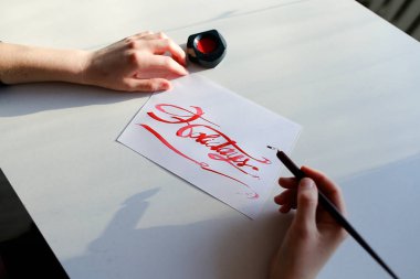 Kadın sanatçı boyalar parlak kitabe mürekkep ile kağıt levha