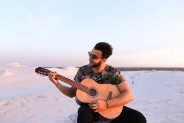 Çekici Arap adam gitar, Hill'de oturan şarkı söylüyor