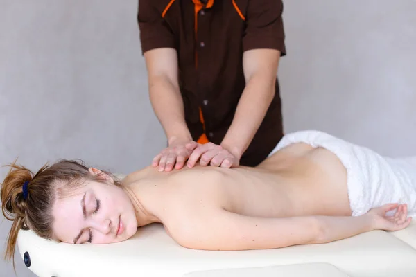 Profesjonalnego masażysty mężczyzna ugniata dziewczyny do pacjenta, którzy leżą — Zdjęcie stockowe
