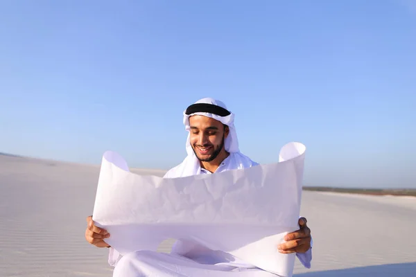 Enterprising male sheikh businessman sitting with white paper in